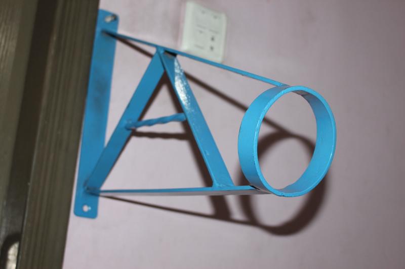 Blue powder coated handrail mounted on pink wall showing installation detail